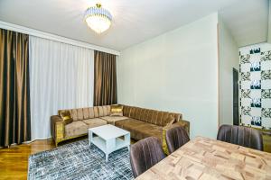 a living room with a couch and a table at Apartment BİCOCCA in Baku