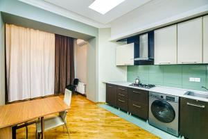 a kitchen with a table and a washing machine at Apartment BİCOCCA in Baku