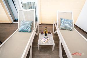 two deck chairs with a table and a bottle of wine at The Segond Hotel in Xagħra