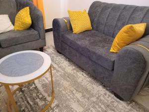 een woonkamer met twee banken en een tafel bij Engra Suites in Nakuru