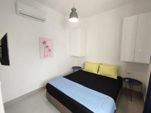 ein Schlafzimmer mit einem Bett mit zwei gelben Kissen in der Unterkunft Large Apartment - Perla Resort, Gjiri i Lalezit in Durrës + 19 Fotos