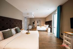 a large bedroom with two beds and a television at The Segond Hotel in Xagħra