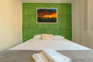 a bedroom with a bed with a green wall at Amplo Aptº em Maringá - Excelente Localização! in Maringá