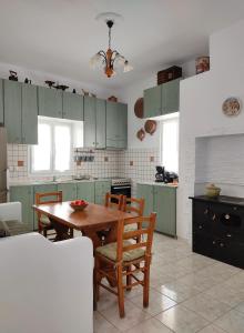 a kitchen with green cabinets and a wooden table and chairs at Casa Centrale in Apollonia +20 photos