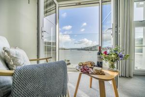 a room with a table with a bottle of wine and flowers at No 26 The Salcombe in Salcombe