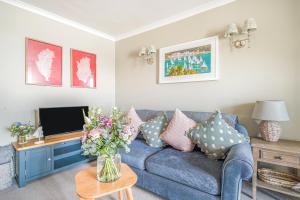 a living room with a blue couch and a tv at No 26 The Salcombe in Salcombe