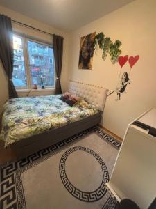 a bedroom with a bed and a window with hearts on the wall at Comfortable room in Oslo