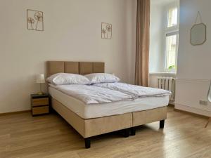 sypialnia z łóżkiem z białą pościelą i oknem w obiekcie Narutowicza 5 Apartments w mieście Inowrocław