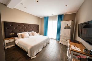 a bedroom with a large bed and a television at The Segond Hotel in Xagħra