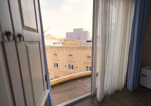 a window with a view of a building at The Segond Hotel in Xagħra
