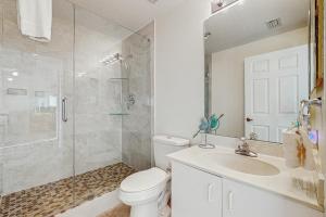 un bagno con doccia, WC e lavandino di Oceanfront condo & WiFi- snowbirds OK! a Palm Coast Altre 22 foto