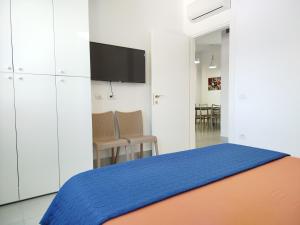 ein Schlafzimmer mit einem Bett und einem Fernseher an der Wand in der Unterkunft Large Apartment - Perla Resort, Gjiri i Lalezit in Durrës