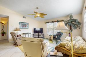 a living room with chairs and a ceiling fan at Paradise Found in Bradenton