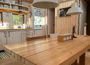 a kitchen with a large wooden table in a room at Enjoy The Atmosphere In Wooden Summer House By The Bay in Højby