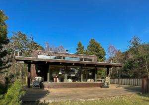 a house with a wooden deck and aconservancyconservancy at Enjoy The Atmosphere In Wooden Summer House By The Bay in Højby +4 photos