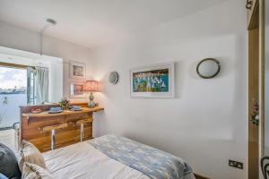 a bedroom with a bed and a desk with a window at No 16 The Salcombe in Salcombe +18 photos