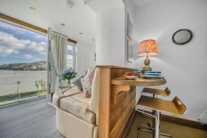 a living room with a couch and a table with a lamp at No 16 The Salcombe in Salcombe