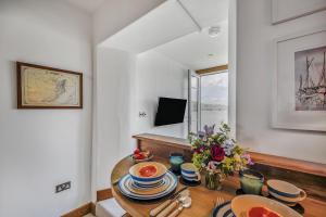a dining room with a table with dishes on it at No 16 The Salcombe in Salcombe
