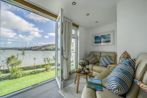 a living room with a couch and a view of the water at No 16 The Salcombe in Salcombe