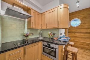 a kitchen with wooden cabinets and a sink and a stove at No 16 The Salcombe in Salcombe +39 photos