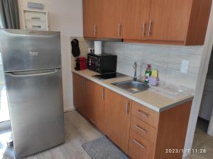 eine Küche mit einem Kühlschrank aus Edelstahl und einer Spüle in der Unterkunft Agriliki Cottage - Amazing View & Nature Escape in Vraná