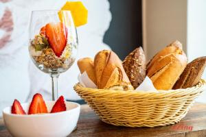 a basket of bread and a glass of wine and strawberries at The Segond Hotel in Xagħra