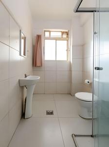 ein weißes Badezimmer mit Waschbecken und Toilette in der Unterkunft Estação 3 qtos - Vista cartão postal - BHSH in Belo Horizonte