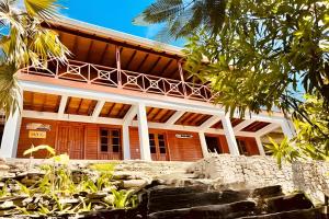 a large building with a balcony on top of it at The Palms at Kitty Wharf – A Luxury Eco-Lodge in the Heart of Providencia in Playa Aguadulce