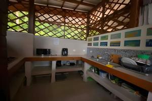 a kitchen with a counter and a sink and a window at The Palms at Kitty Wharf – A Luxury Eco-Lodge in the Heart of Providencia in Playa Aguadulce