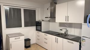 a white kitchen with white cabinets and a sink at Center Apart Hannover in Hannover