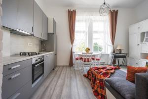 a kitchen with white cabinets and a table with chairs at Katica's Ribnjak Retreat in Zagreb