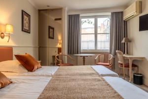 a hotel room with a bed and a table and chairs at Hotel Ter Duinen in Bruges