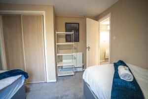 een kleine slaapkamer met twee bedden en een kast bij 2 BDR Flat By Caledonia Luxe Stays Short Lets & Serviced Accommodation Coatbridge in Coatbridge