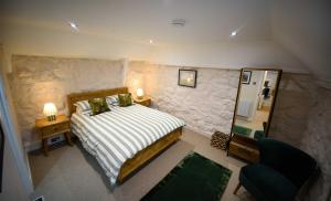 a bedroom with a king sized bed and a mirror at Katie Ann's Thatched Cottage in Luib