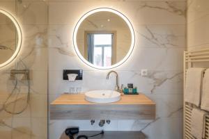 a bathroom with a sink and two mirrors at Hotel Ter Duinen in Bruges +45 photos