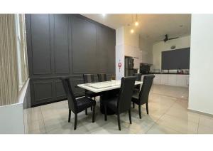 a dining room with a table and black chairs at Permai Homestay Twin in Bukit Mertajam
