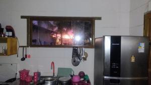a kitchen with a stainless steel refrigerator and a window at River House in Marau