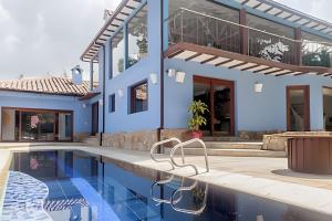 una villa con piscina di fronte a una casa di Casa Azul - Casa de Lujo Bogotá a Bogotá