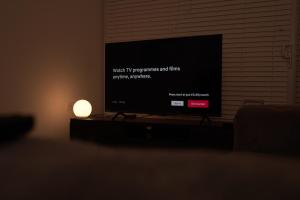 a television screen in a living room with a lamp at Harborne Park House in Birmingham