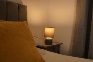 a lamp sitting on a table next to a bed at Harborne Park House in Birmingham +14 photos