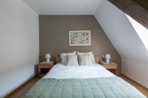 a bedroom with a bed with a green blanket at LE RHENANUS Hans Sapidus - appartement spacieux, au calme - parking gratuit in Sélestat