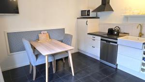 a small kitchen with a wooden table and a sink at DJP76 mooi gelijkvloers appartement met terras in Domburg
