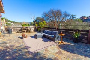 eine Terrasse mit einem blauen Sofa und einem Tisch in der Unterkunft Catalunya Casas Unique villa in Costa Maresme 27km to Barcelona! in Argentona