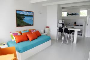 a bedroom with a bed with orange and blue pillows at South End Villas - Colombian Caribbean Apartments in San Andrés
