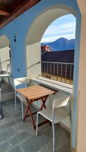 a table and chairs on a balcony with a view at Casa Angelino in Cannobio