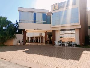 a building with tables and chairs in front of it at Executive Hotel MT in Lucas do Rio Verde
