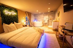 a bedroom with a large bed and a bath room at Spa beige room in Berstett