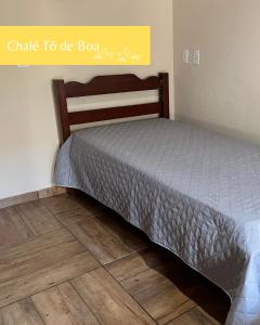 ein Schlafzimmer mit einem Bett und einem Holzboden in der Unterkunft Chalés Toatoa e Tô de Boa - Conceição de Ibitipoca in Lima Duarte