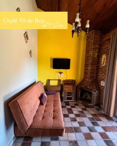 ein Wohnzimmer mit Sofa und Fernseher in der Unterkunft Chalés Toatoa e Tô de Boa - Conceição de Ibitipoca in Lima Duarte