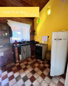 eine Küche mit einem weißen Kühlschrank und einer Spüle in der Unterkunft Chalés Toatoa e Tô de Boa - Conceição de Ibitipoca in Lima Duarte + 8 Fotos